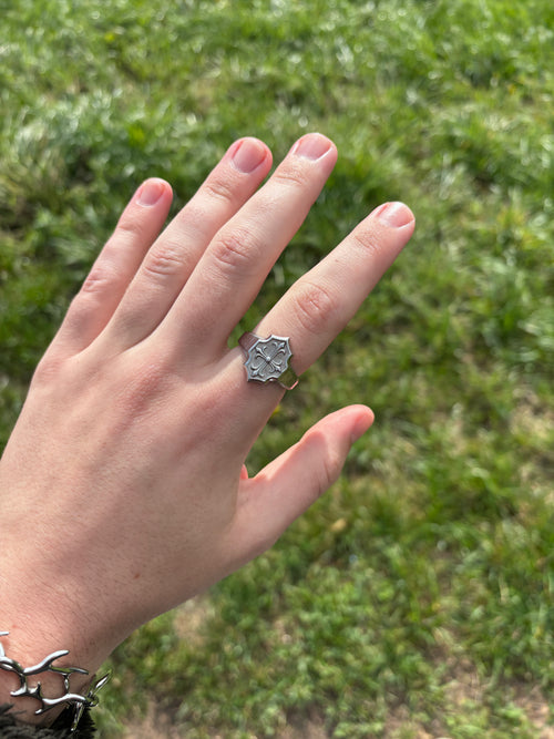 Lily Cross Ring aus 316L-Edelstahl an der Hand getragen, Wappenplatte mit Lilien-Kreuz