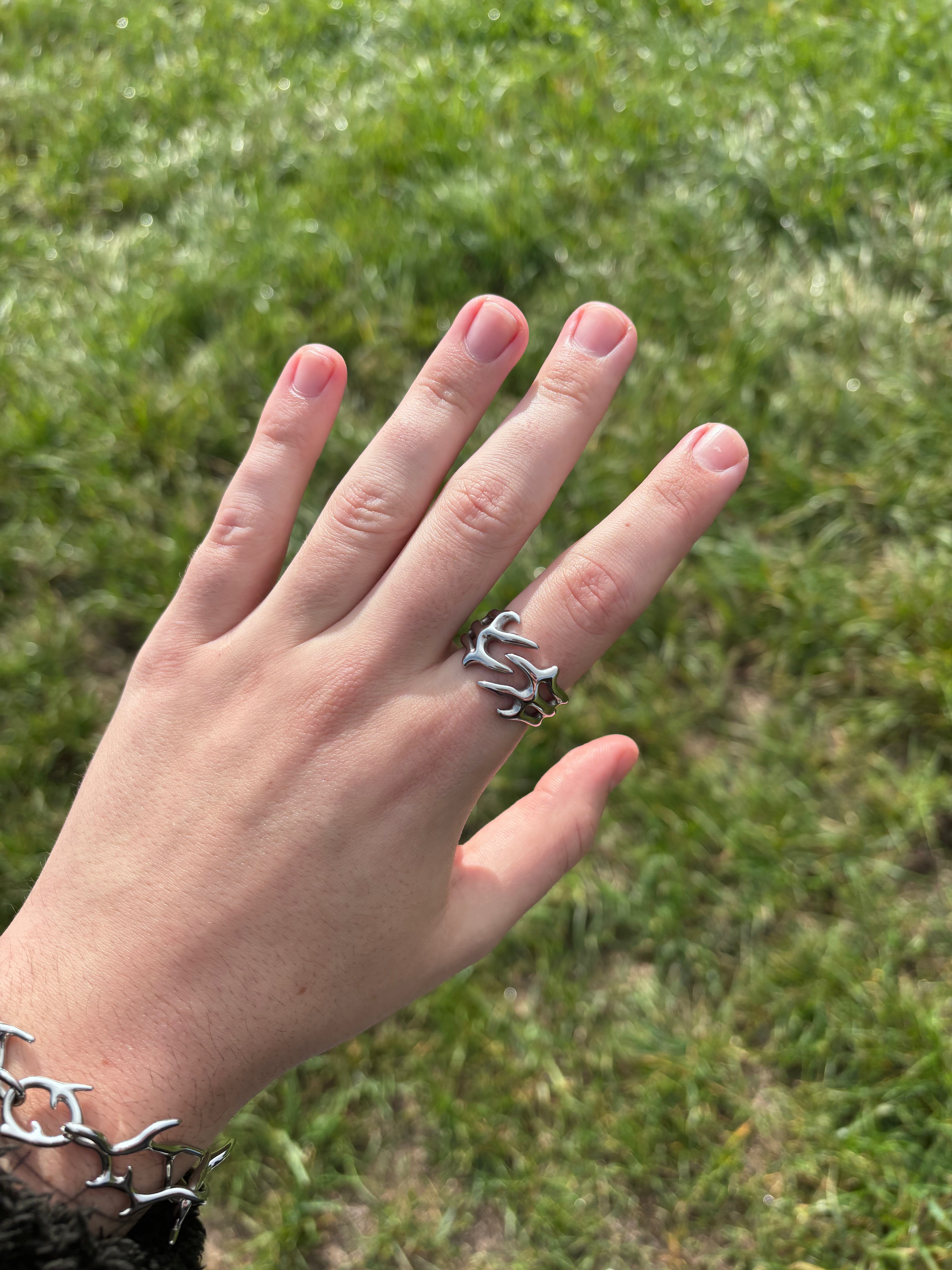 Thorn Embrace Ring aus 316L-Edelstahl an der Hand getragen, breite Dornenranken